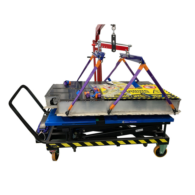 A battery lifting hoist being used inconjuction with an engine crane and battery lifting table.